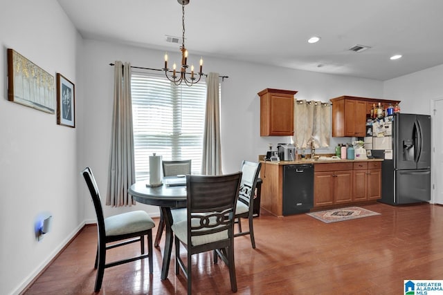 dining space featuring dark hardwood / wood-style flooring, sink, and a chandelier