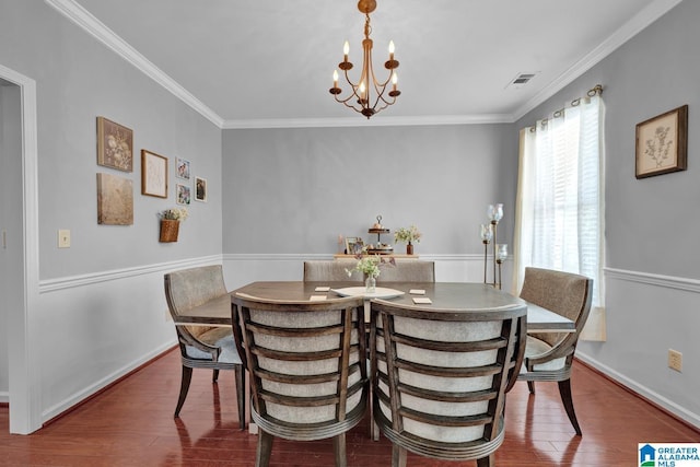 dining space with dark hardwood / wood-style floors, an inviting chandelier, and ornamental molding