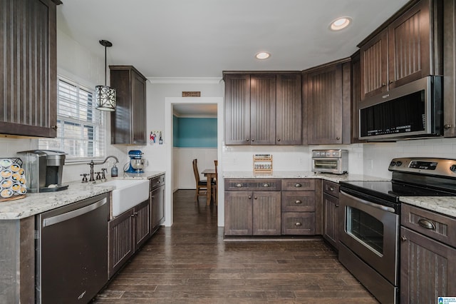 kitchen with stainless steel appliances, decorative light fixtures, sink, and dark brown cabinets