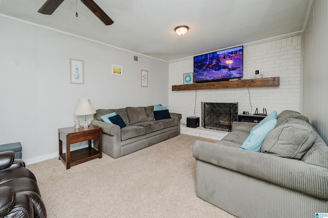 carpeted living room with ceiling fan, a fireplace, ornamental molding, and a textured ceiling