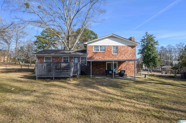 rear view of property featuring a patio area, a deck, and a yard