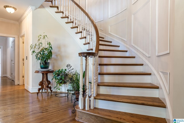 staircase featuring crown molding and hardwood / wood-style floors