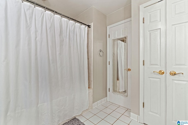 bathroom featuring tile patterned floors and shower / bath combo with shower curtain