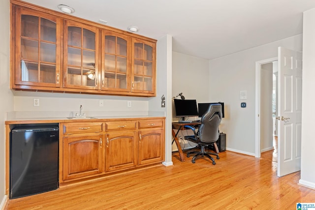 office area with light hardwood / wood-style floors and sink