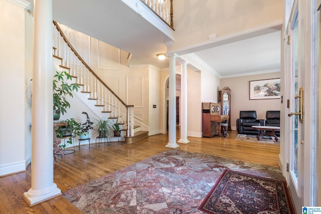 foyer entrance with wood-type flooring and ornamental molding