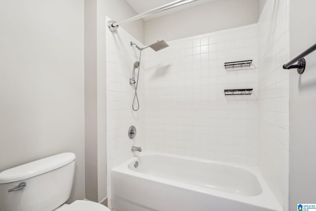 bathroom featuring toilet and tiled shower / bath combo