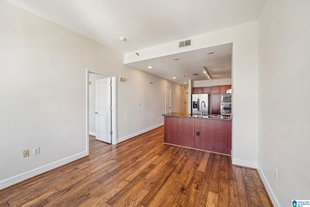 kitchen featuring sink, stainless steel appliances, kitchen peninsula, and dark hardwood / wood-style floors