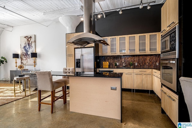 kitchen featuring light brown cabinets, stainless steel appliances, backsplash, island range hood, and a kitchen island