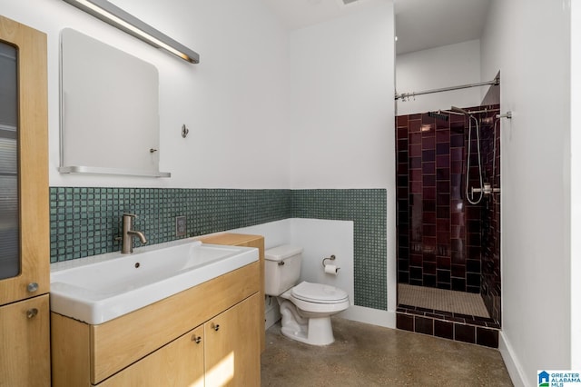 bathroom featuring tiled shower, vanity, and toilet