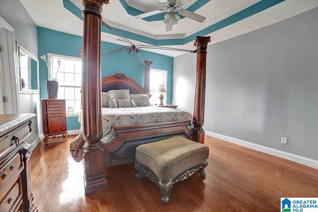 bedroom with multiple windows, wood-type flooring, and decorative columns