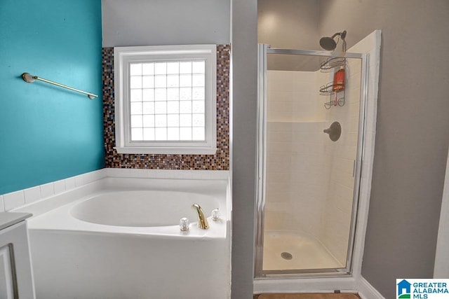 bathroom featuring shower with separate bathtub