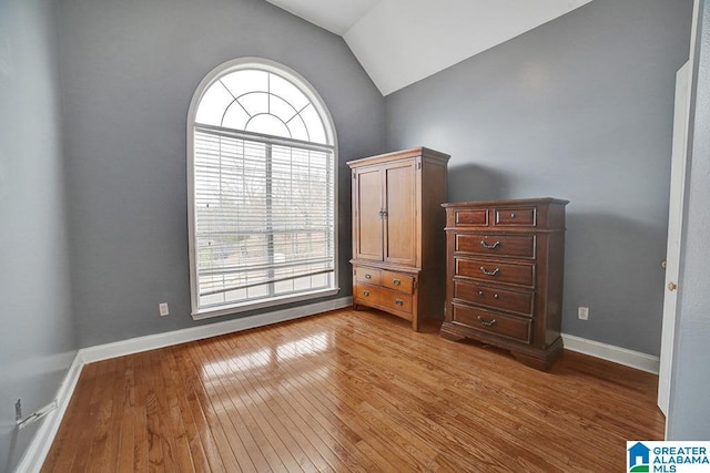 unfurnished bedroom with lofted ceiling and light hardwood / wood-style floors