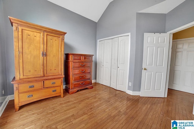 bedroom featuring lofted ceiling, a closet, and light wood-type flooring