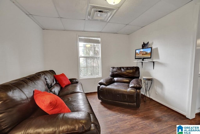 living room featuring a drop ceiling and dark hardwood / wood-style flooring