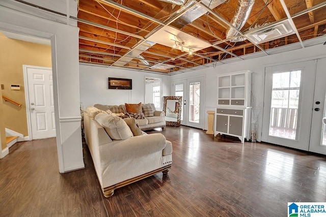 living room featuring dark wood-type flooring, plenty of natural light, and french doors