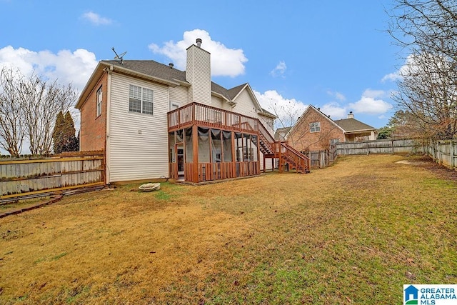 back of house featuring a wooden deck and a lawn