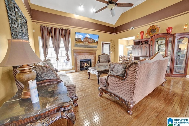 living room with ceiling fan, vaulted ceiling, and light hardwood / wood-style flooring