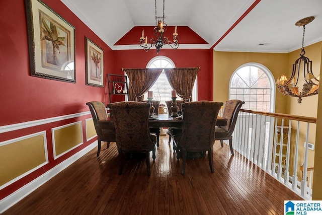 dining area with wood-type flooring, vaulted ceiling, a healthy amount of sunlight, and a notable chandelier