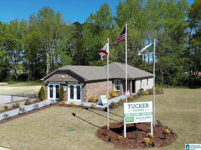 view of front of home with a front lawn and french doors