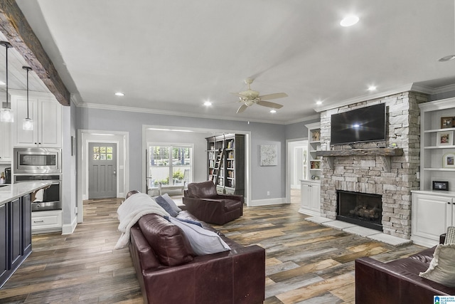 living room featuring a fireplace, dark hardwood / wood-style flooring, ceiling fan, and crown molding