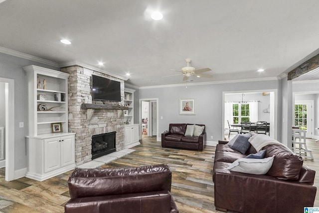 living room with a fireplace, hardwood / wood-style flooring, ceiling fan, and ornamental molding