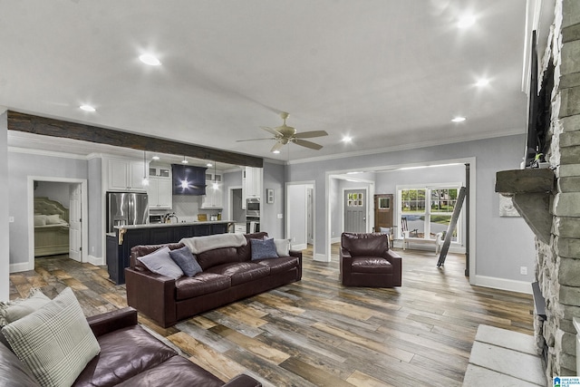 living room with hardwood / wood-style flooring, ceiling fan, and ornamental molding