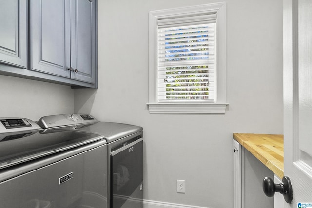 clothes washing area with cabinets and independent washer and dryer