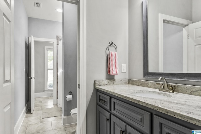 bathroom featuring tile patterned floors, vanity, and toilet