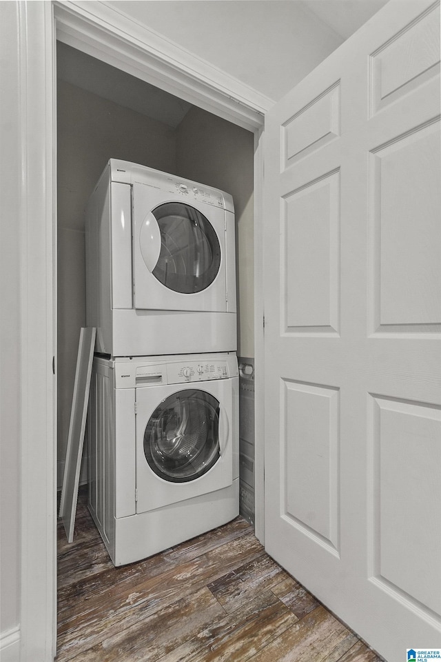 laundry room featuring dark hardwood / wood-style floors and stacked washer and clothes dryer