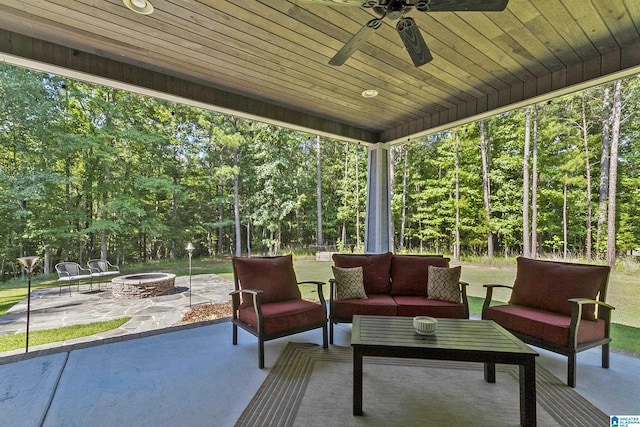 view of patio with ceiling fan and an outdoor living space with a fire pit