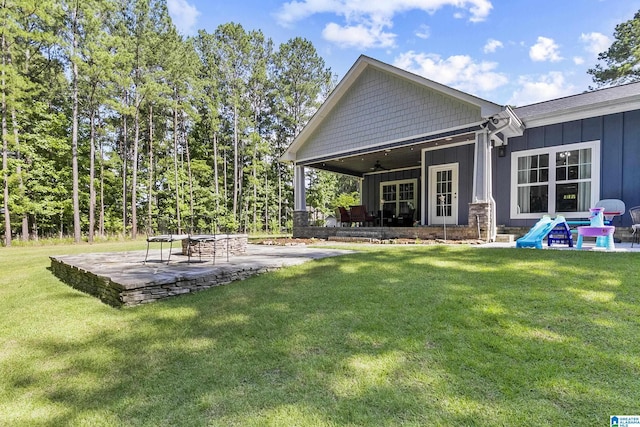 view of yard with ceiling fan and a patio