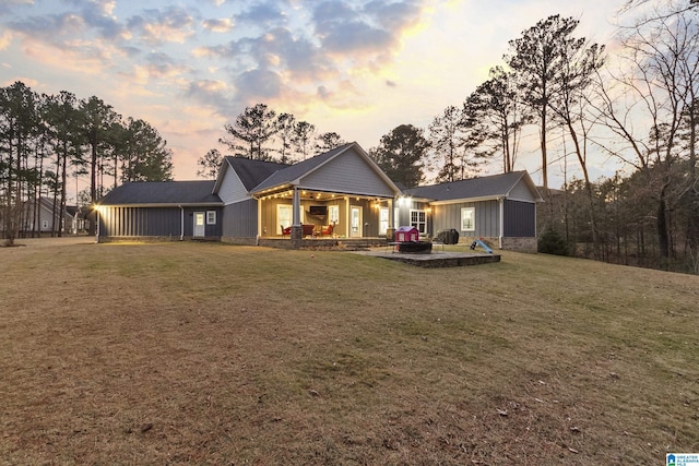 back house at dusk with a yard and a patio