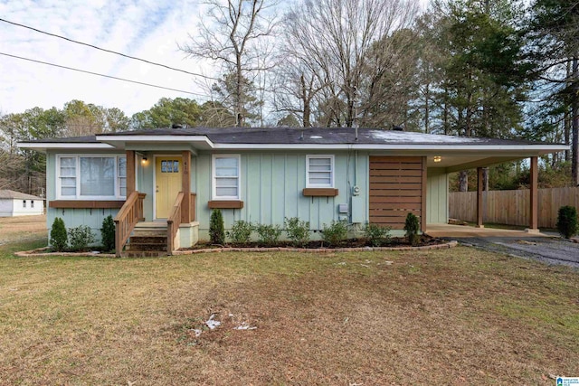 view of front of house with a carport and a front lawn