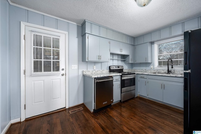 kitchen with dark hardwood / wood-style flooring, sink, stainless steel appliances, and a textured ceiling