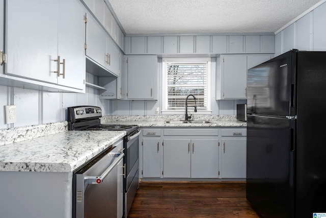 kitchen with dark hardwood / wood-style floors, sink, stainless steel appliances, and a textured ceiling