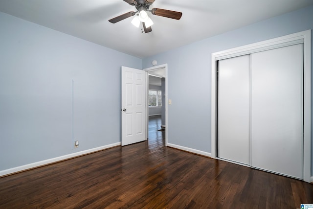 unfurnished bedroom featuring dark hardwood / wood-style flooring, a closet, and ceiling fan