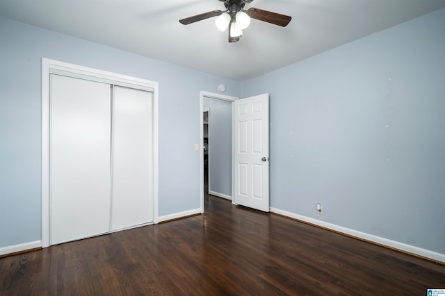 unfurnished bedroom with ceiling fan, a closet, and dark wood-type flooring