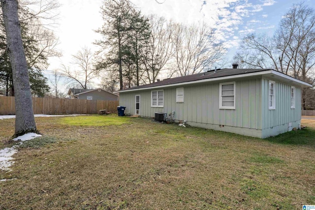 rear view of house featuring cooling unit and a yard