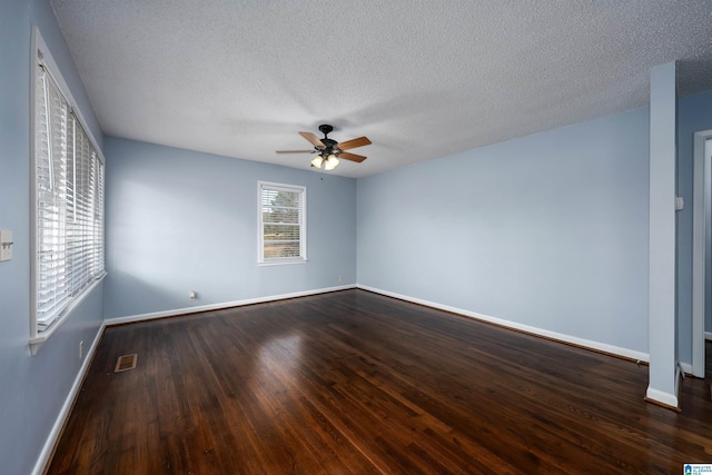 unfurnished room featuring dark hardwood / wood-style floors, ceiling fan, and a textured ceiling