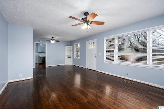 unfurnished living room featuring a textured ceiling, ceiling fan, and dark hardwood / wood-style floors