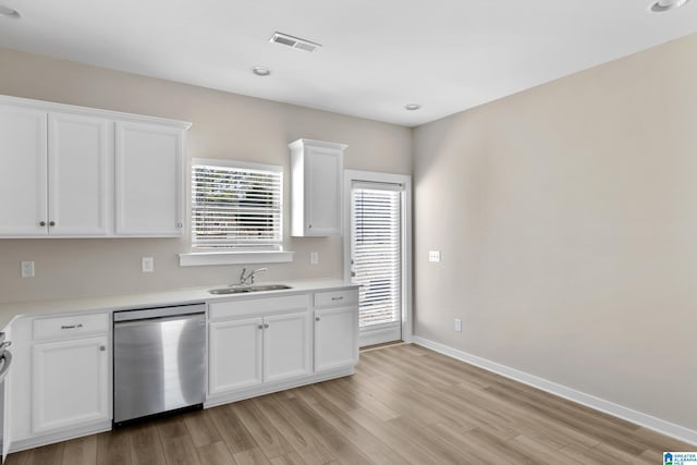 kitchen with light wood-type flooring, stainless steel dishwasher, white cabinets, and sink