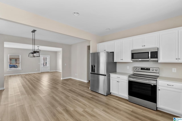 kitchen featuring light hardwood / wood-style floors, white cabinetry, stainless steel appliances, and pendant lighting