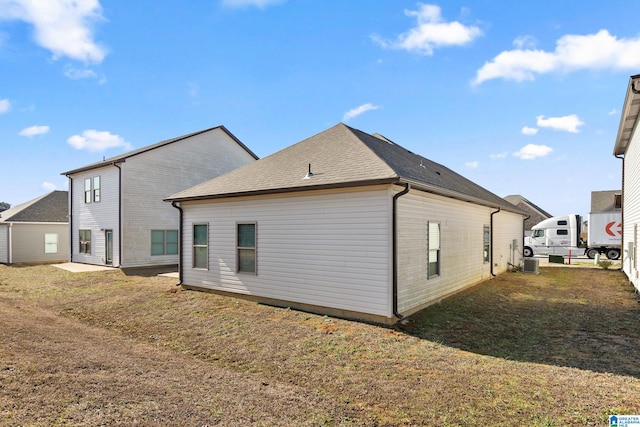 back of property featuring cooling unit and a yard