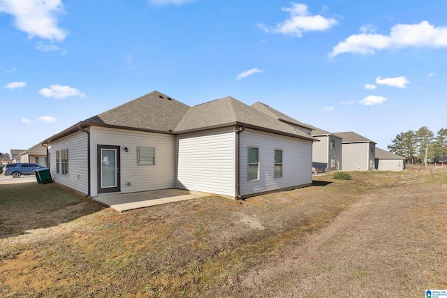 back of house with a patio area and a yard