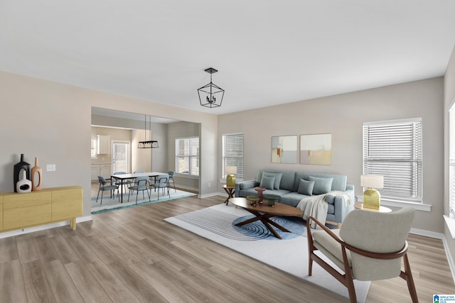 living room with light wood-type flooring and a chandelier