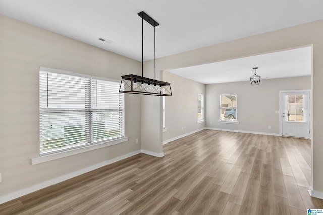 unfurnished dining area featuring a wealth of natural light and light wood-type flooring