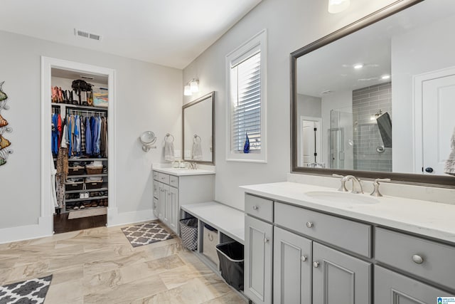 bathroom featuring a shower with door and vanity