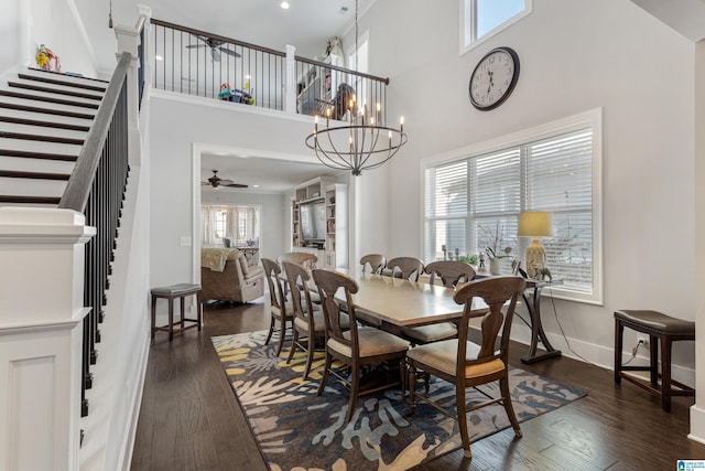 dining area featuring ceiling fan with notable chandelier, a healthy amount of sunlight, and dark hardwood / wood-style floors