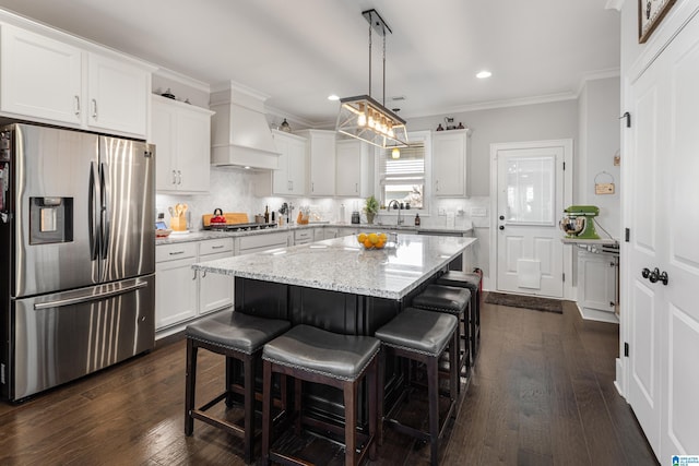 kitchen featuring stainless steel appliances, a center island, premium range hood, pendant lighting, and backsplash