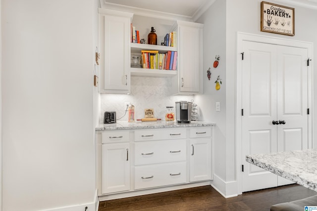 bar with white cabinetry, light stone counters, decorative backsplash, crown molding, and dark wood-type flooring